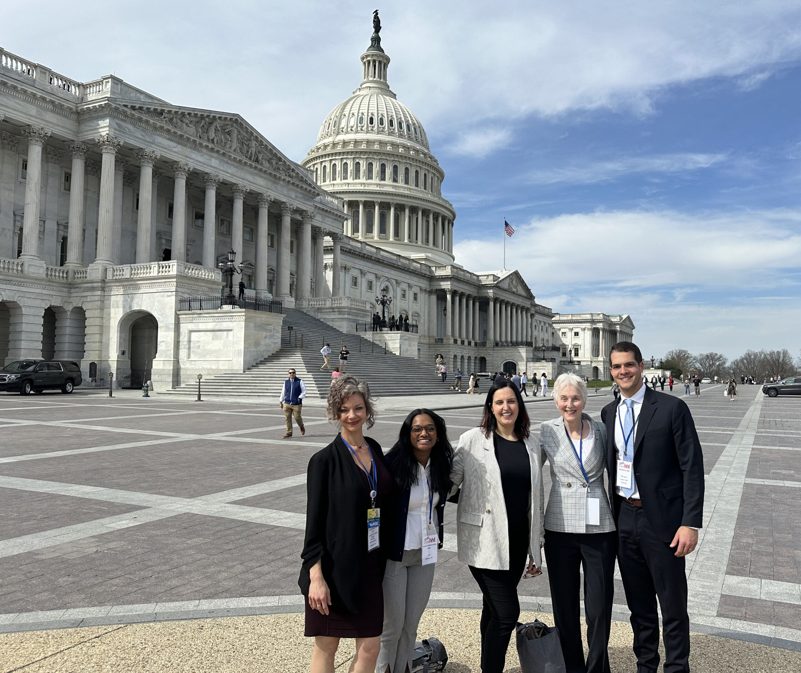 Five people posing together outside the US Capitol building