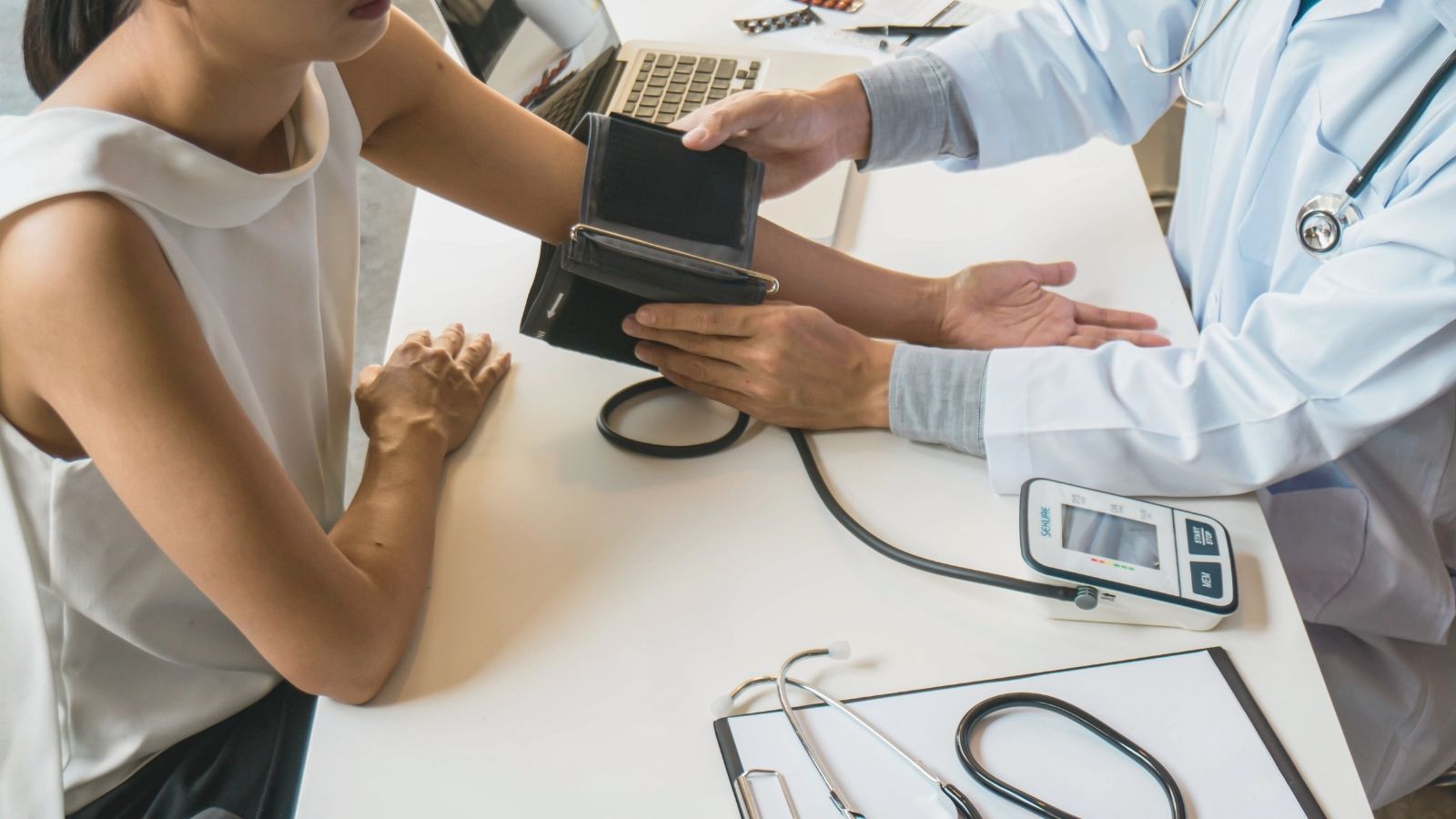 A clinician taking a patient's blood pressure during an office visit