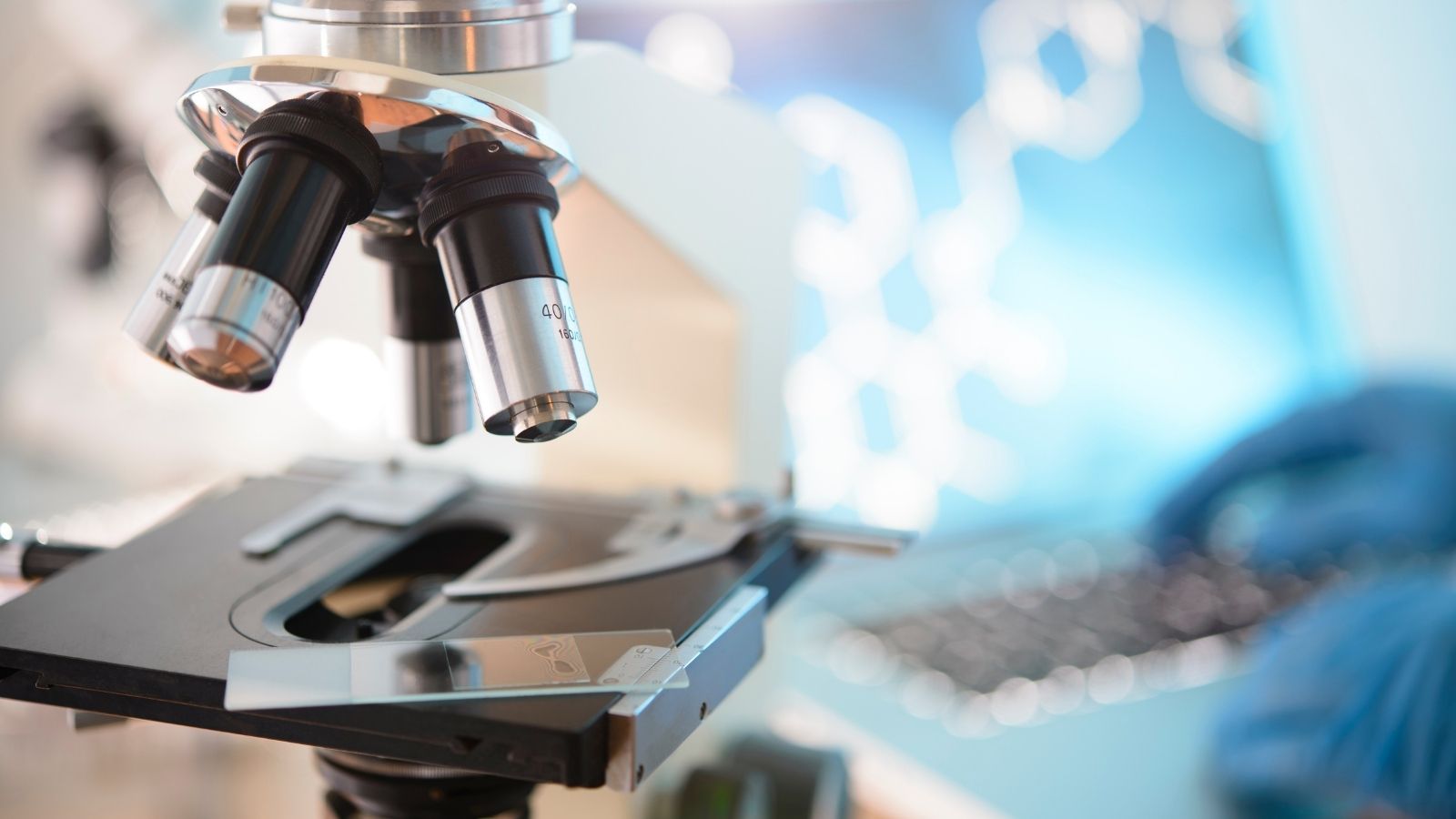 A laboratory microscope in front of blurred lab equipment